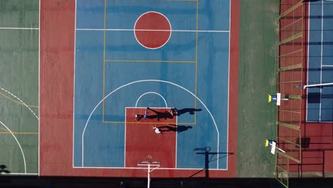 Top-down-aerial-view-of-people-playing-on-basketball-court