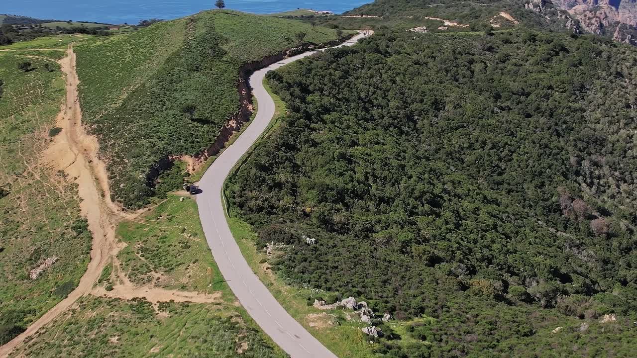 Carretera serpenteante entre las colinas de Córcega, Francia, durante un día soleado