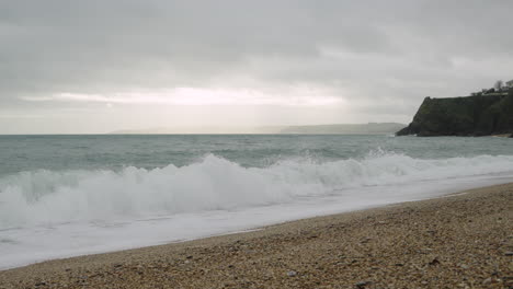 la fría y gris costa inglesa en un día de invierno con olas que chocan contra la playa