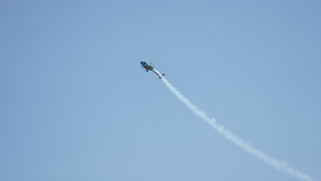 skilled helicopter pilot executing precise aerial maneuvers, generating dramatic white smoke trail against vibrant blue sky backdrop