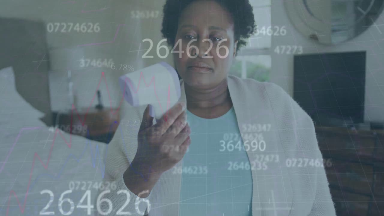 Numeri in continuo cambiamento su donna anziana afroamericana che misura la sua temperatura a casa