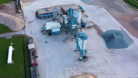 asphalt mixing machine in an asphalt factory, mounds of crushed stone as the main material