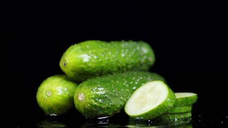 whole and slices of cucumber rotate slowly.