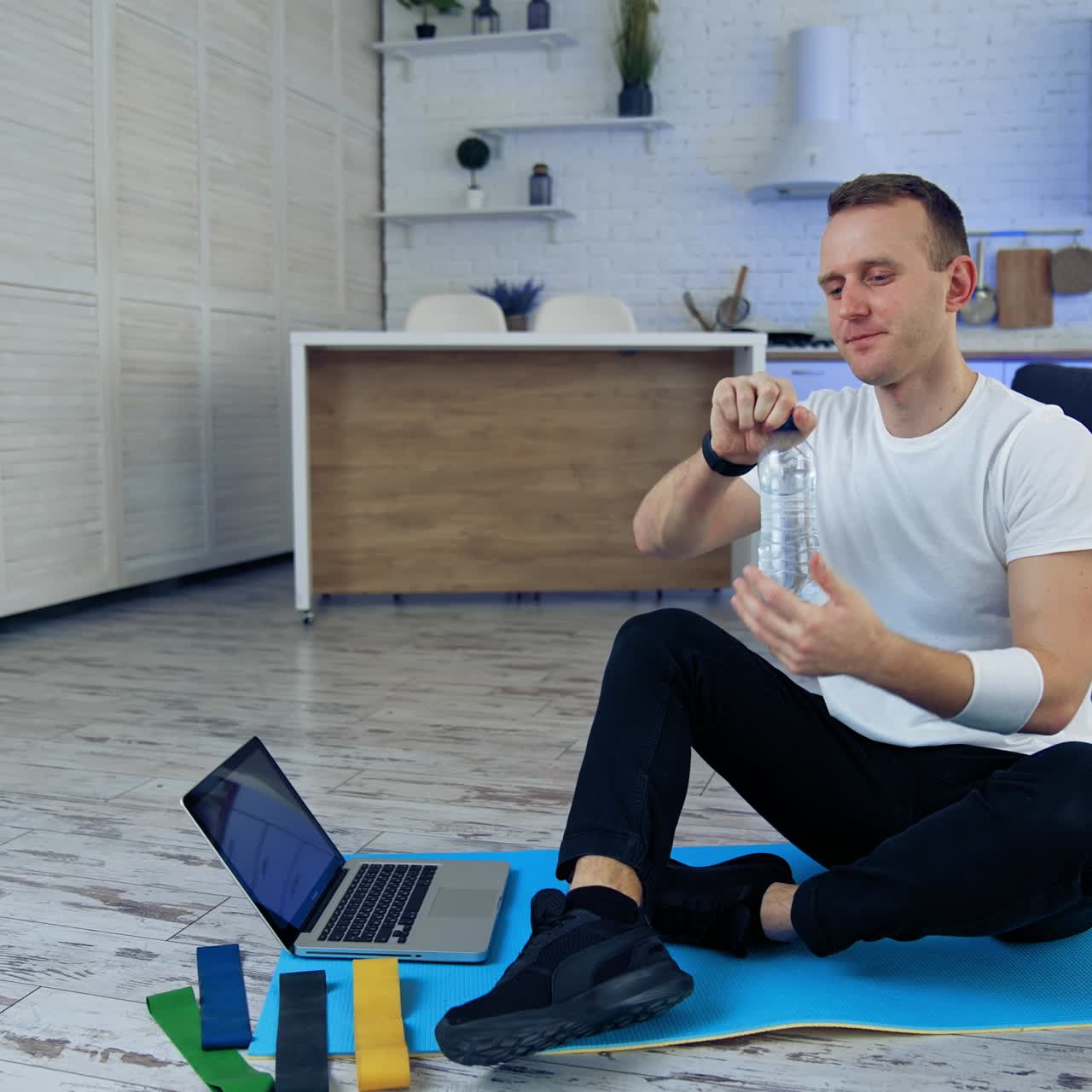 Man after exercise at home. Male sportsman resting after online fitness at home