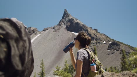 chica de senderismo con laboratorio negro y montaña en el fondo