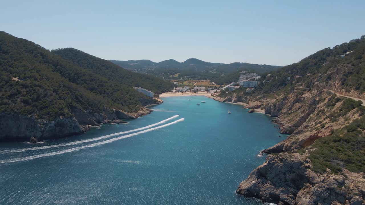 Luftfoto af to jetski, der suser mod bugten ved Cala Llonga på Ibiza