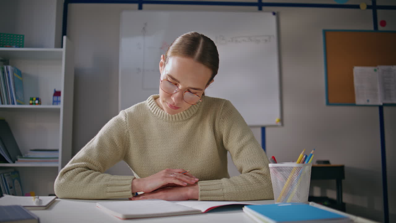 Attentive lady working school light day closeup. Woman in glasses putting marks
