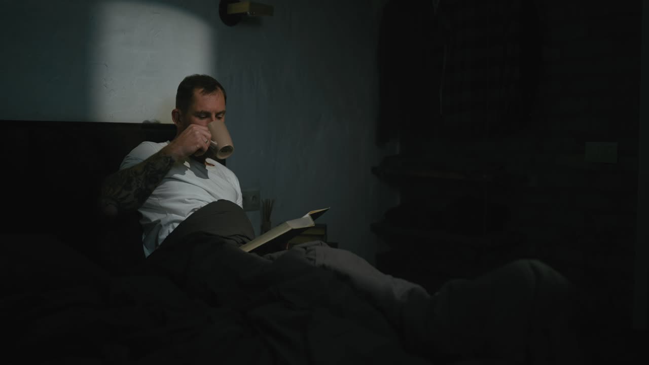 hombre leyendo en la cama con café
