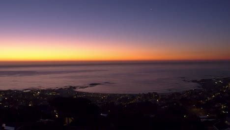 fotografía panorámica de mano de una ciudad junto al mar al atardecer