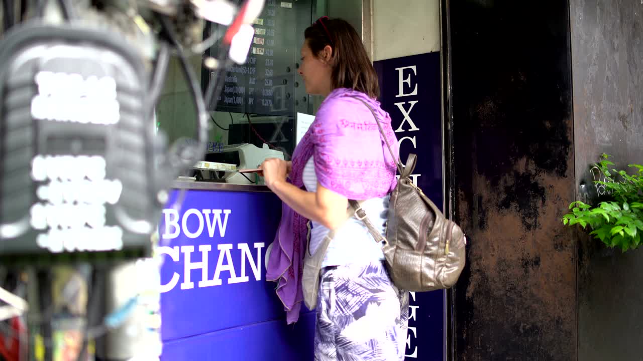 한 여인이 화폐를 교환하기 위해 와서 돈을 줍니다.