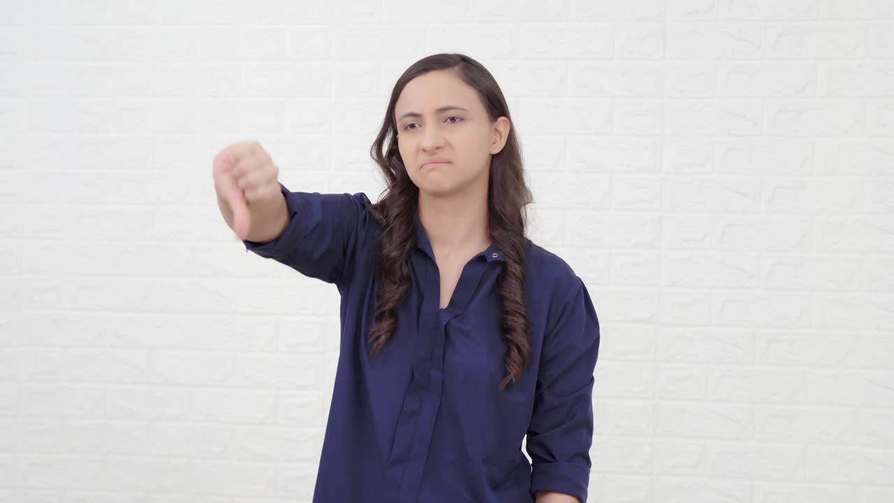 un indio decepcionado mostrando los pulgares hacia abajo