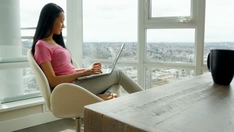 Woman-using-laptop-in-living-room-4k