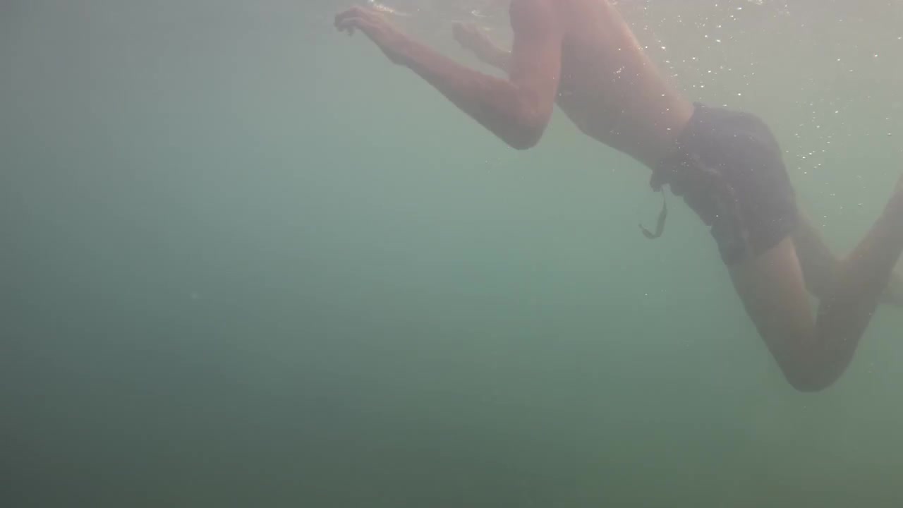 Man swimming underwater, showing movement, freedom, and a refreshing feeling in natural water