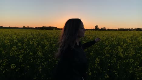 Bellas-Mujeres-Corriendo-Por-El-Campo-De-Colza-Durante-La-Puesta-De-Sol