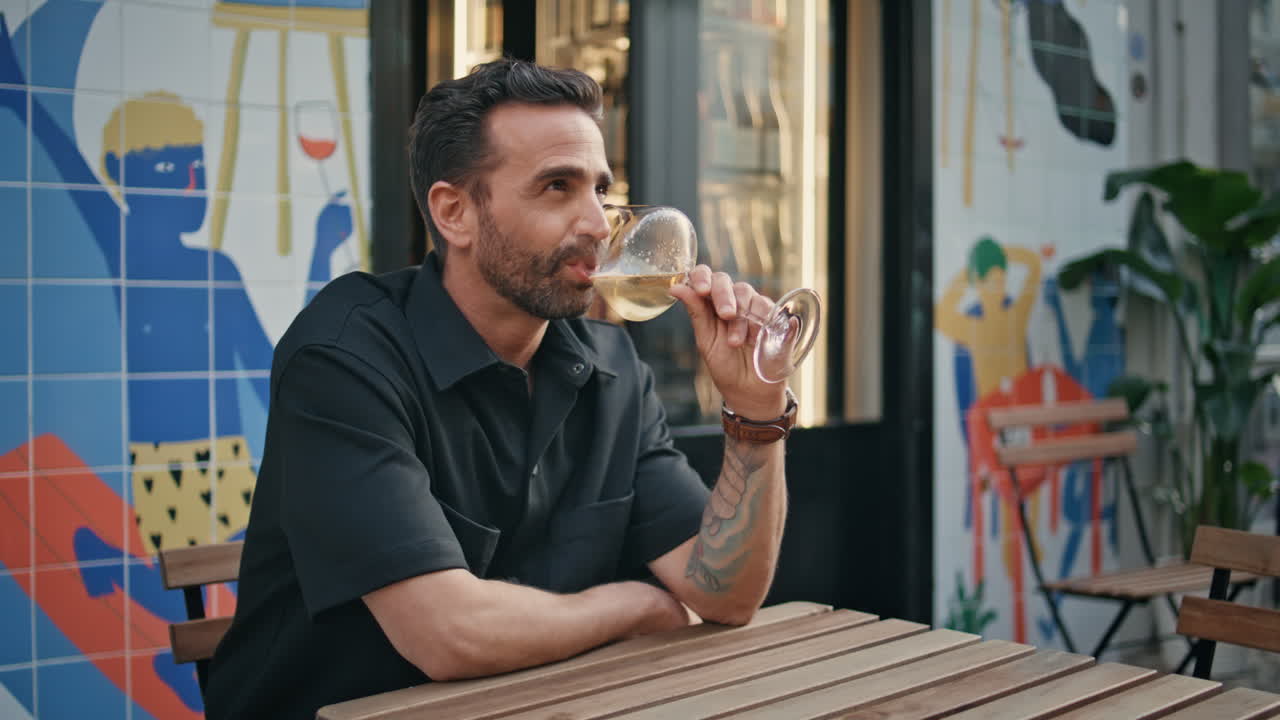 Tourist drinking wine glass at urban cafe closeup. Man sipping alcohol