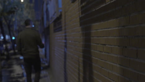 person walking down a city alley at night