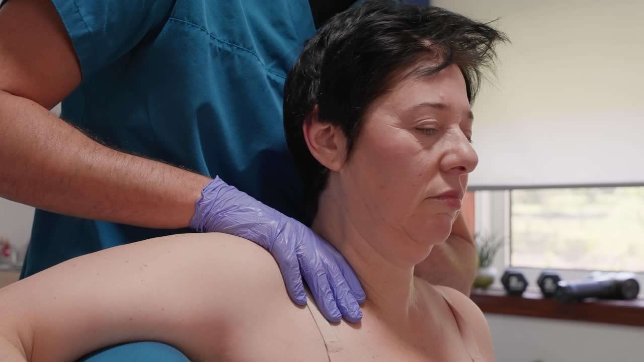 chiropractor applies shoulder pressure during clinical therapy with woman