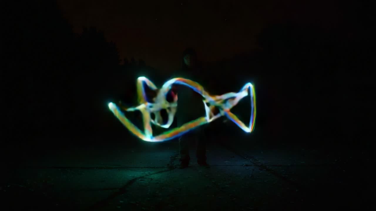 A mesmerizing display of light trails captured in a dark environment, showcasing the dynamic movement and vibrant colors of light as they weave through the night air