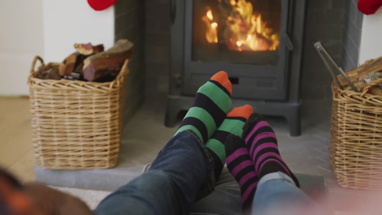 행복한 아프리카계 미국인 부부는 줄무 ⁇  양말을 입고 바닥에 앉아 있습니다.