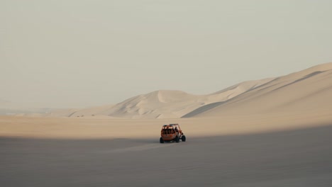 traveling buggy over dune sand landscape in huacachina, peru. tracking shot
