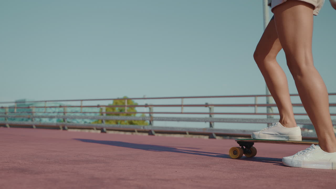 Woman Skateboarding on a Bridge