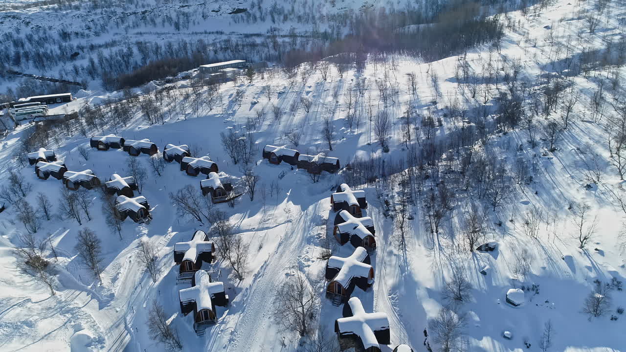 스노우 호텔 키르케네스(snow hotel kirkenes)에 있는 십자형 오두막의 눈 덮인 지붕의 탁 트인 전망과 노르웨이의 새로운 날을 상징하는 풍경에 떨어지는 햇빛
