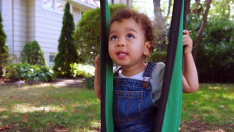 Niña-Feliz-Jugando-En-El-Columpio-Del-Jardín