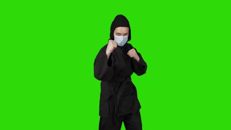 shooting of woman in black costume ninja on isolated background