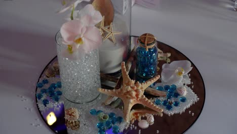 beach wedding centerpiece with seashells, starfish, and orchids