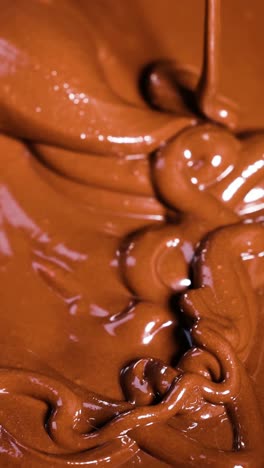 spoon stirring rich, melted chocolate in bowl