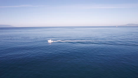 drone video captures the vast sea along the coasts of puerto vallarta, featuring a luxury yacht cruising through the deep blue waters, showcasing the beauty of the ocean and the vessel