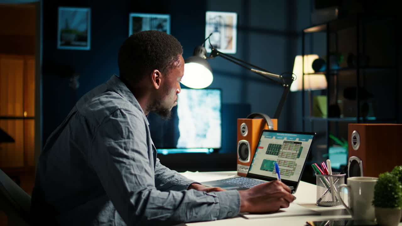 uomo nero autonomo multitasking a casa prendendo appunti scritti a mano