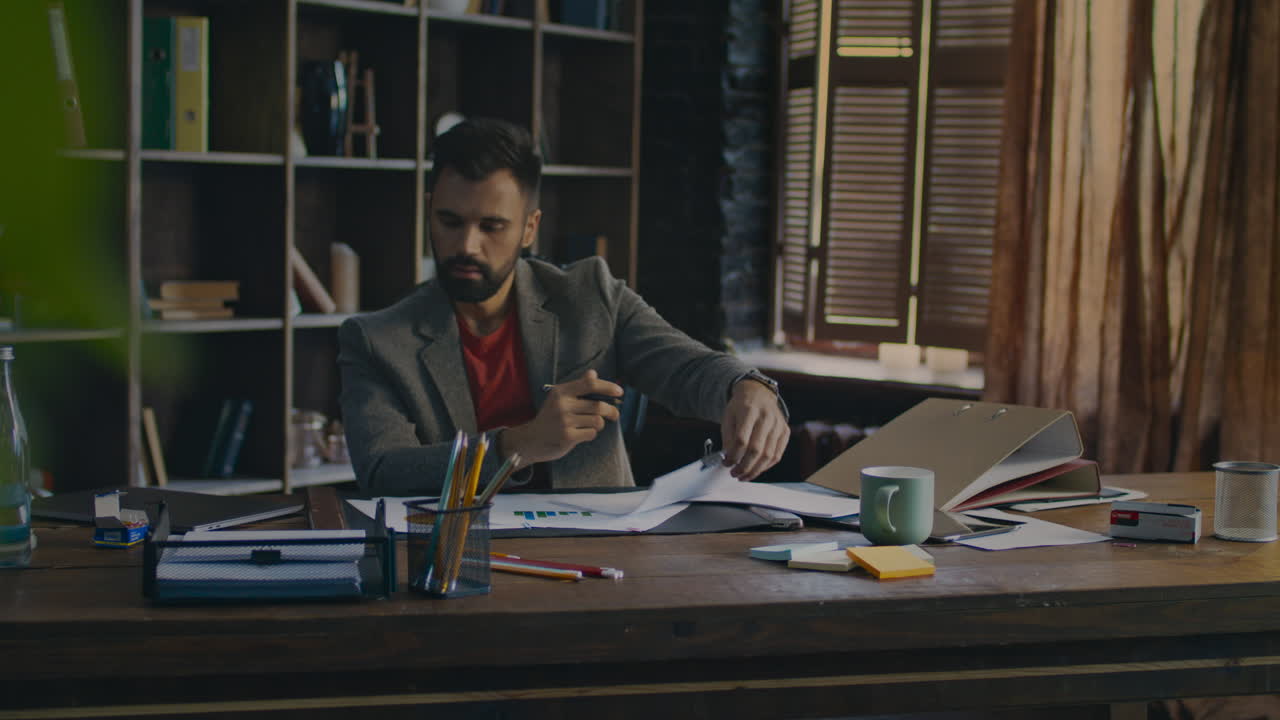 Businessman signing document at office. Tired man working with papers