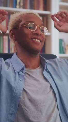 young african american man puts hands behind head and takes relaxed pose