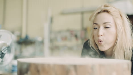 Female-Carpenter-Blowing-Sawdust