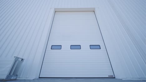 facade (front view) of a large hangar lined with a metal profile.