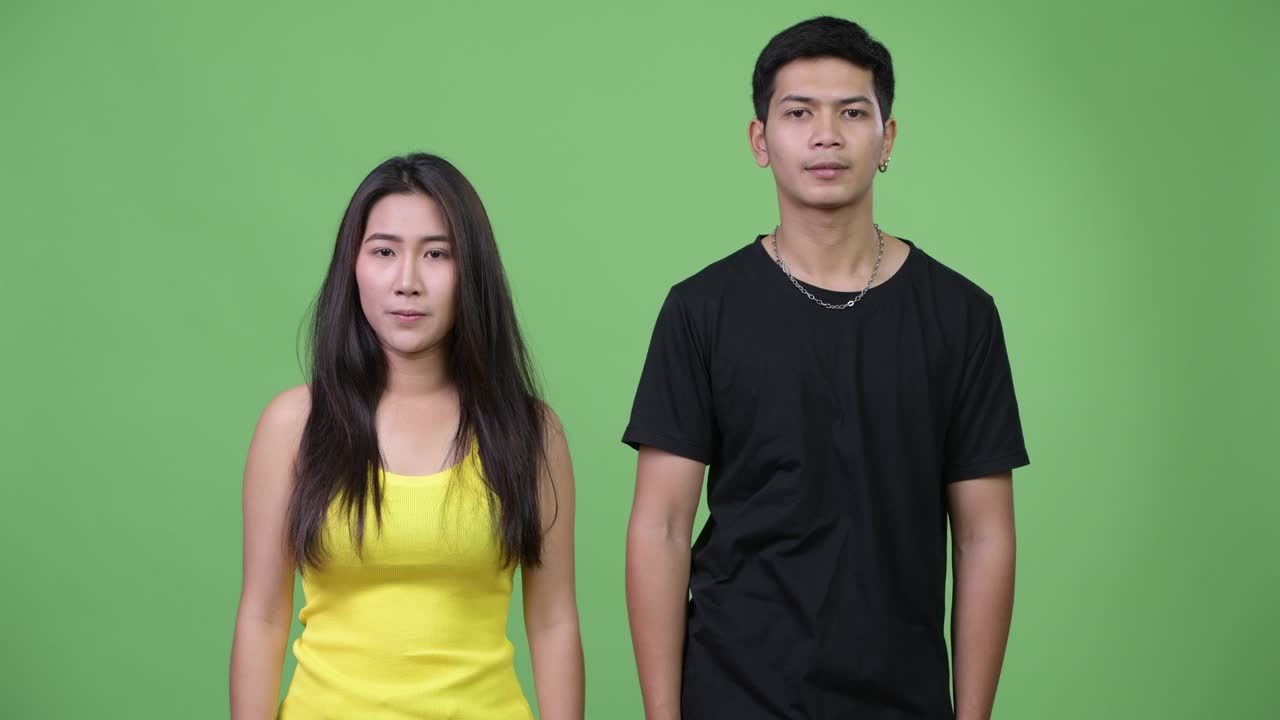 Young happy Asian couple giving handshake together