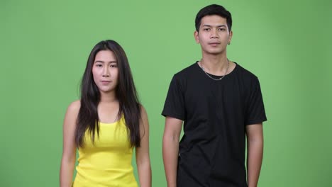 young happy asian couple giving handshake together