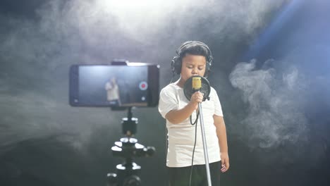 young boy singing into microphone, recording video