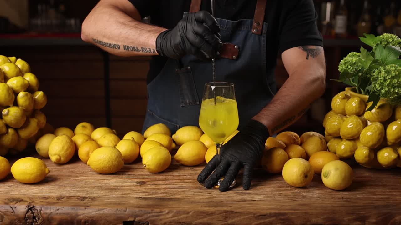 Bartender preparing a cocktail with fresh lemons