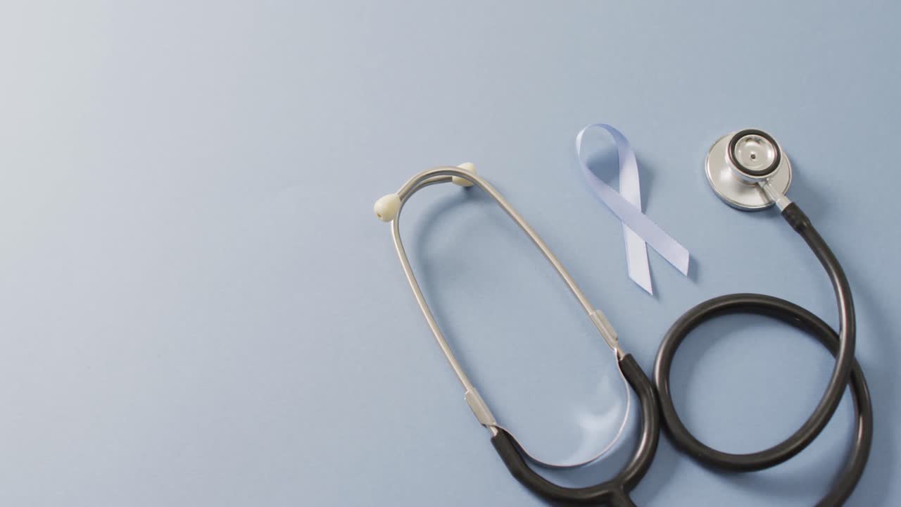 Video di stetoscopio e nastro azzurro chiaro per il cancro alla prostata su sfondo azzurro chiaro