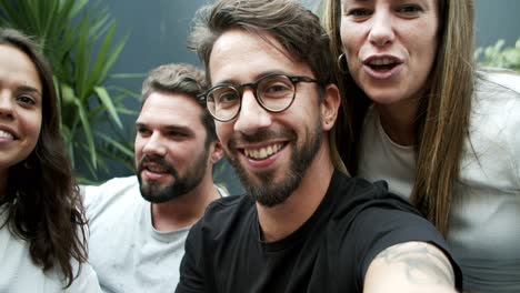 Cheerful-friends-talking-and-waving-to-camera