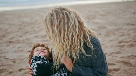 loving mother having fun with cute little son on beach closeup. happy child rest