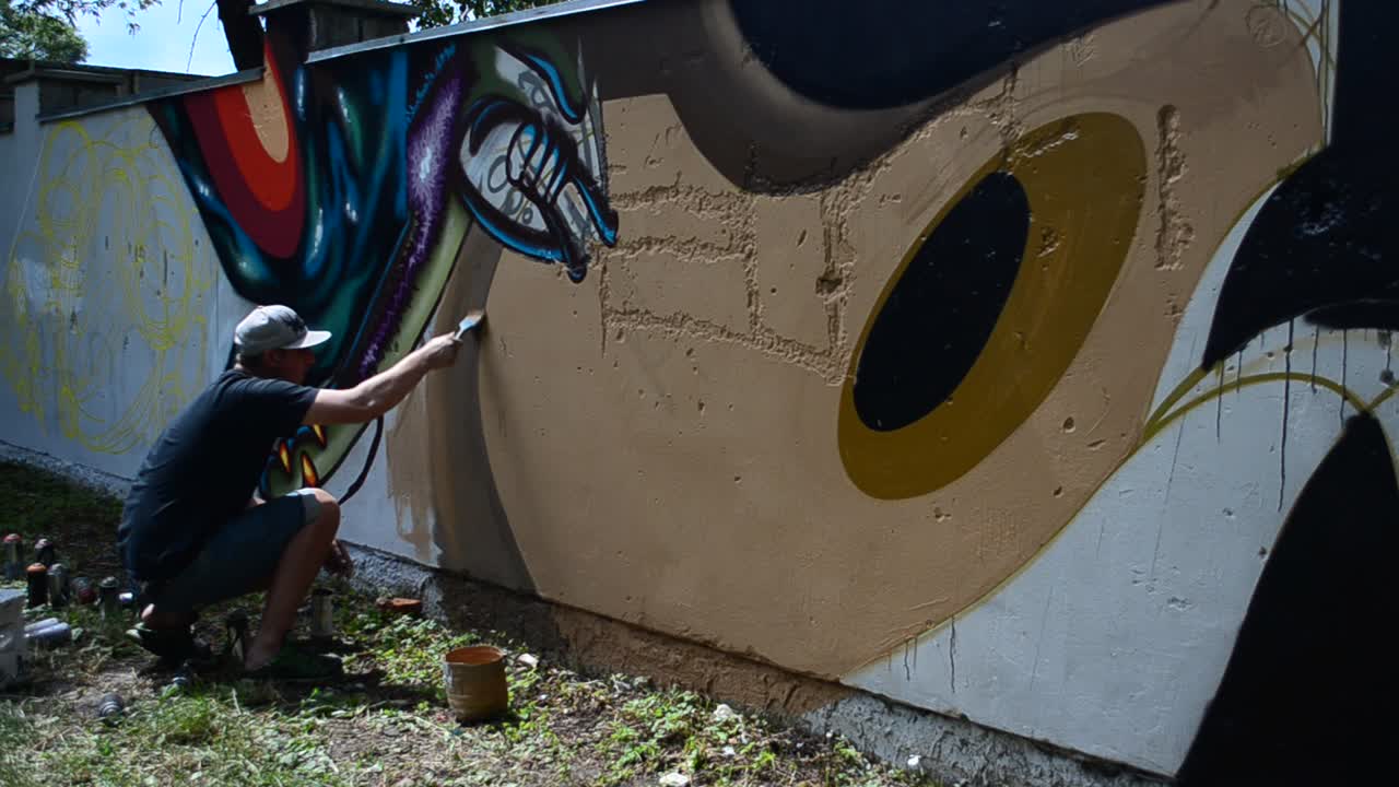 Processen med at skabe graffiti, hegn. Kunstneren tegner graffiti.