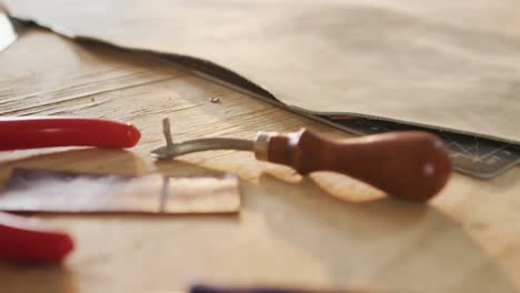 close up of tools lying on table in leather workshop