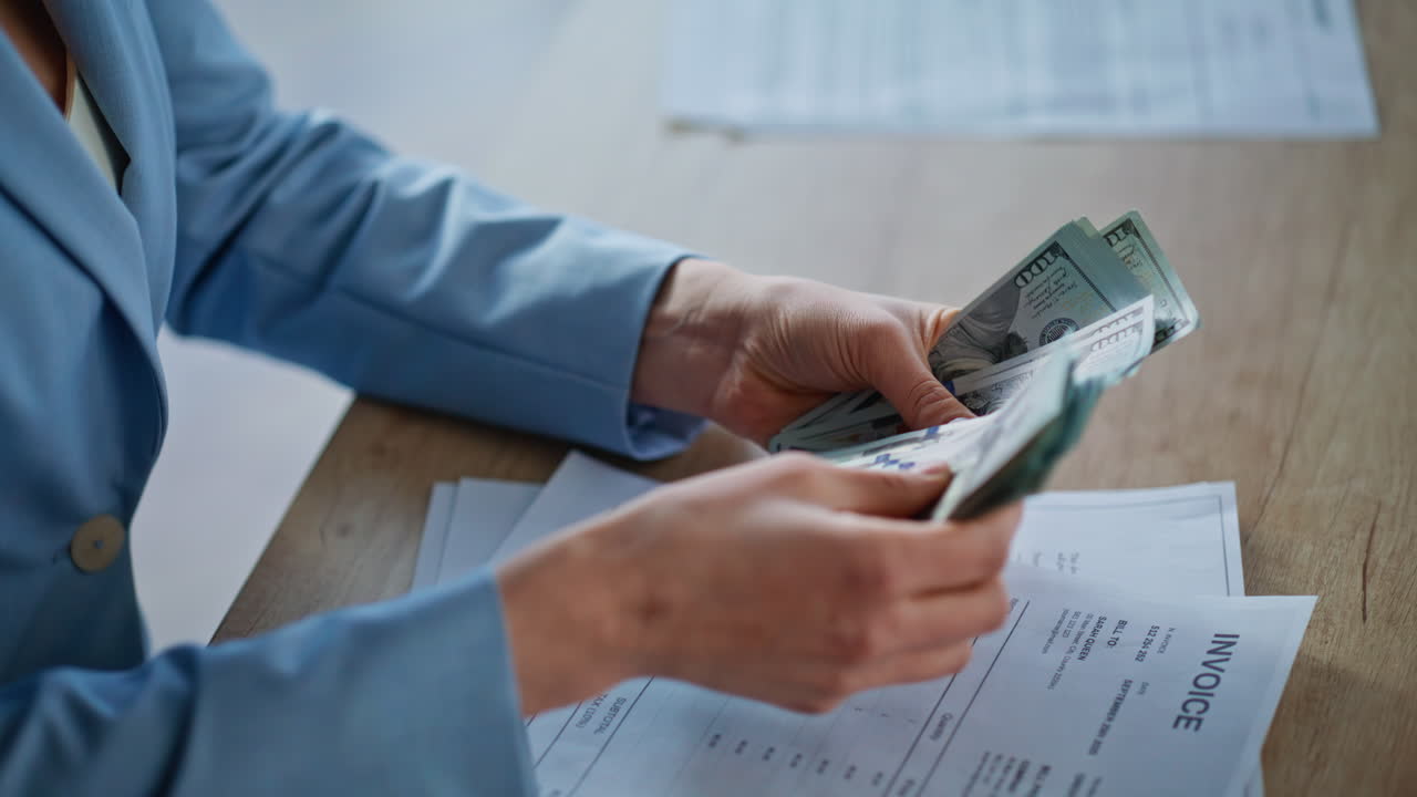 Businesswoman hands counting dollars at wooden desk closeup. Woman holding money