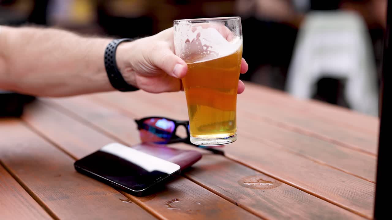 mano alcanzando y recogiendo un vaso de cerveza