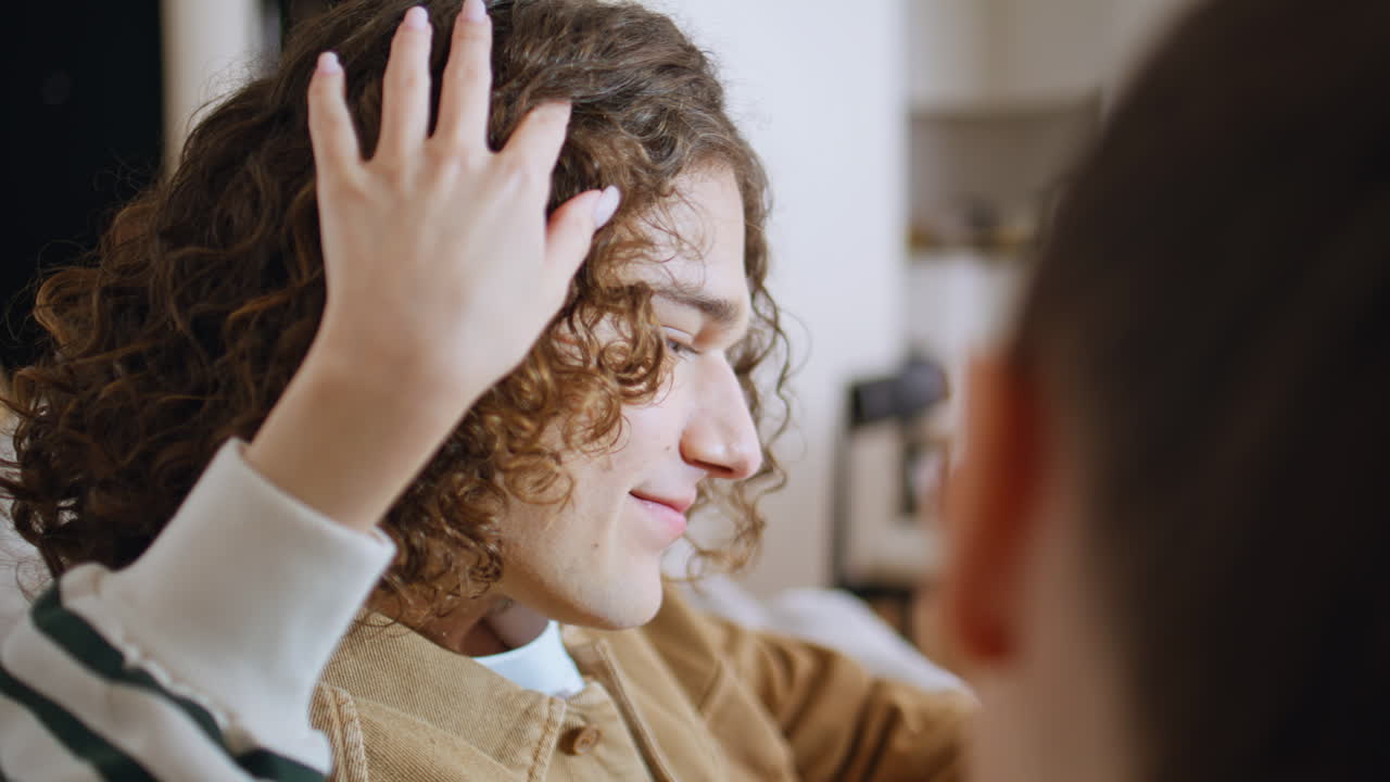 Romantic soulmates kissing sofa cozy home closeup. Woman hand caressing hair
