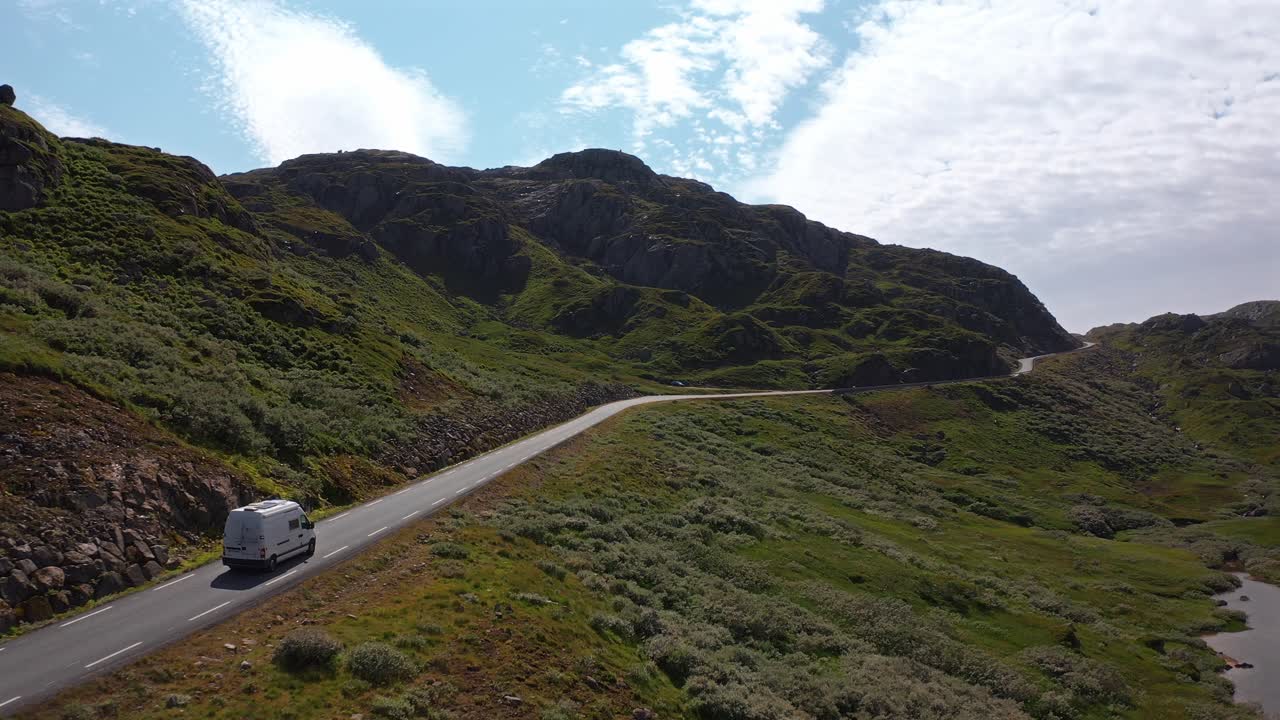Winding road in Norway with a camper van driving through a scenic landscape