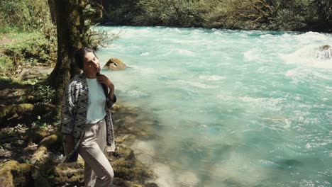 mujer por un río de montaña turquesa